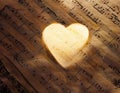 Love Music. Light heart on vintage music sheet Royalty Free Stock Photo