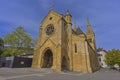 The Collegial Church of NeuchÃ¢tel, Switzerland, with gothic towers and stone faÃ§ade under a clear blue sky on a quiet morning Royalty Free Stock Photo