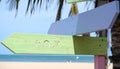 Pastel colored wooden direction signs, beach and palm tree background Royalty Free Stock Photo