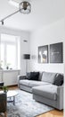 White elegant living room interior with windows, grey corner sofa and modern art posters Royalty Free Stock Photo