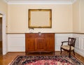 Vintage living room interior with a patterned rug, cupboard, golden frame on the wall Royalty Free Stock Photo