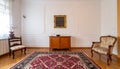 Vintage living room interior with a patterned rug, cupboard, golden frame on the wall Royalty Free Stock Photo