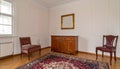 Vintage living room interior with a patterned rug, cupboard, golden frame on the wall Royalty Free Stock Photo