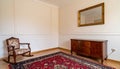Vintage living room interior with a patterned rug, cupboard, golden frame on the wall Royalty Free Stock Photo