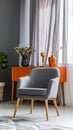 Grey armchair at orange table in dark retro living room interior with drapes Royalty Free Stock Photo