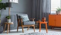 Grey armchair at orange table in dark retro living room interior with drapes Royalty Free Stock Photo