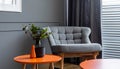 Grey armchair at orange table in dark retro living room interior with drapes Royalty Free Stock Photo
