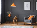 Orange lamp above table and grey armchair in dark vintage living room interior Royalty Free Stock Photo