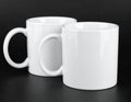 Two blank white mugs on black background. Mockup for design Royalty Free Stock Photo