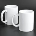 Two blank white mugs on black background. Mockup for design Royalty Free Stock Photo