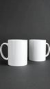Two blank white mugs on black background. Mockup for design Royalty Free Stock Photo