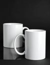 Two blank white mugs on black background. Mockup for design Royalty Free Stock Photo
