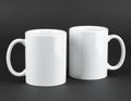 Two blank white mugs on black background. Mockup for design Royalty Free Stock Photo
