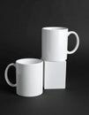 Two blank white mugs on black background. Mockup for design Royalty Free Stock Photo
