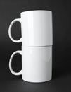 Two blank white mugs on black background. Mockup for design Royalty Free Stock Photo