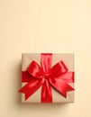 Gift box with red bow on beige background, top view. Space for text Royalty Free Stock Photo