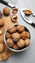 Fresh walnuts in bowl and nutcracker on gray table, flat lay. Royalty Free Stock Photo