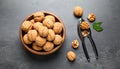 Fresh walnuts in bowl and nutcracker on gray table, flat lay. Royalty Free Stock Photo