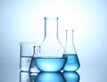 Laboratory glassware on mirror surface against light background, space for text Royalty Free Stock Photo