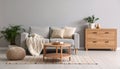 Soft sofa, coffee table, pouf, houseplants and chest of drawers near grey wall in live room Royalty Free Stock Photo