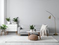 Soft sofa, coffee table, pouf, houseplants and chest of drawers near grey wall in live room Royalty Free Stock Photo