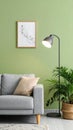 Stylish sofa with pillow, houseplant and lamp near green wall indoors Royalty Free Stock Photo