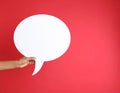 Woman holding blank speech bubble on red background, closeup. Space for text Royalty Free Stock Photo