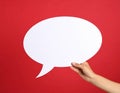 Woman holding blank speech bubble on red background, closeup. Space for text Royalty Free Stock Photo