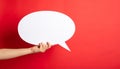 Woman holding blank speech bubble on red background, closeup. Space for text Royalty Free Stock Photo