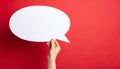 Woman holding blank speech bubble on red background, closeup. Space for text Royalty Free Stock Photo