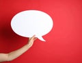 Woman holding blank speech bubble on red background, closeup. Space for text Royalty Free Stock Photo