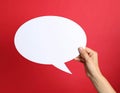 Woman holding blank speech bubble on red background, closeup. Space for text Royalty Free Stock Photo