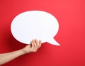 Woman holding blank speech bubble on red background, closeup. Space for text Royalty Free Stock Photo