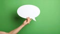 Woman holding blank speech bubble on green background, closeup. Space for text Royalty Free Stock Photo