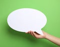 Woman holding blank speech bubble on green background, closeup. Space for text Royalty Free Stock Photo