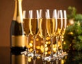 Brown background with blurry light on glasses of champagne and bottle on mirror surfa Royalty Free Stock Photo