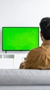 The man who watches modern TV with a green screen at home Royalty Free Stock Photo