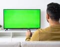 The man who watches modern TV with a green screen at home Royalty Free Stock Photo