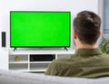 The man who watches modern TV with a green screen at home Royalty Free Stock Photo