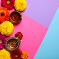 Diwali celebration. Diya lamps and beautiful flowers on colorful background, closed. Royalty Free Stock Photo