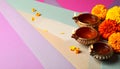 Diwali celebration. Diya lamps and beautiful flowers on colorful background, closed. Royalty Free Stock Photo