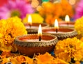 Diwali celebration. Diya lamps and beautiful flowers on colorful background, closed. Royalty Free Stock Photo