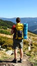 Tourist with backpack in mountains, back view Royalty Free Stock Photo