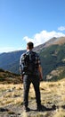 Tourist with backpack in mountains, back view Royalty Free Stock Photo