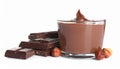 Chocolate pieces, glass of delicious paste and hazelnuts on white background Royalty Free Stock Photo