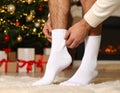 Man putting on white socks at home, closeup Royalty Free Stock Photo