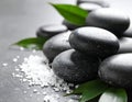 Spa stones, sea salt and leaves on grey table Royalty Free Stock Photo