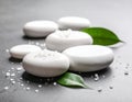 Spa stones, sea salt and leaves on grey table Royalty Free Stock Photo