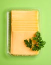 Pack of sliced, Cheese on green background, top view Royalty Free Stock Photo