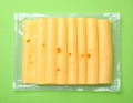 Pack of sliced, Cheese on green background, top view Royalty Free Stock Photo
